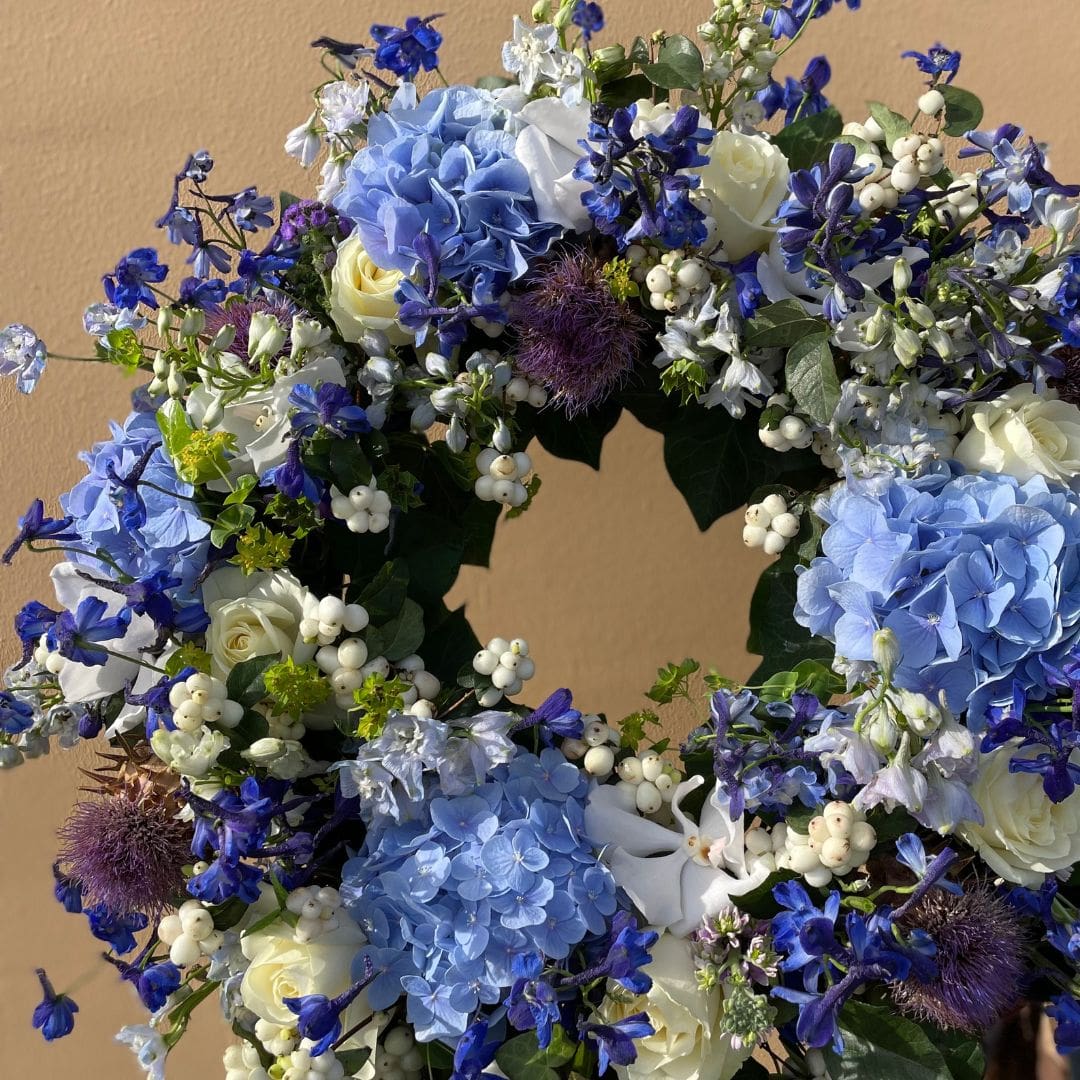 blomsterkrans til begravelse i blå og lilla farver