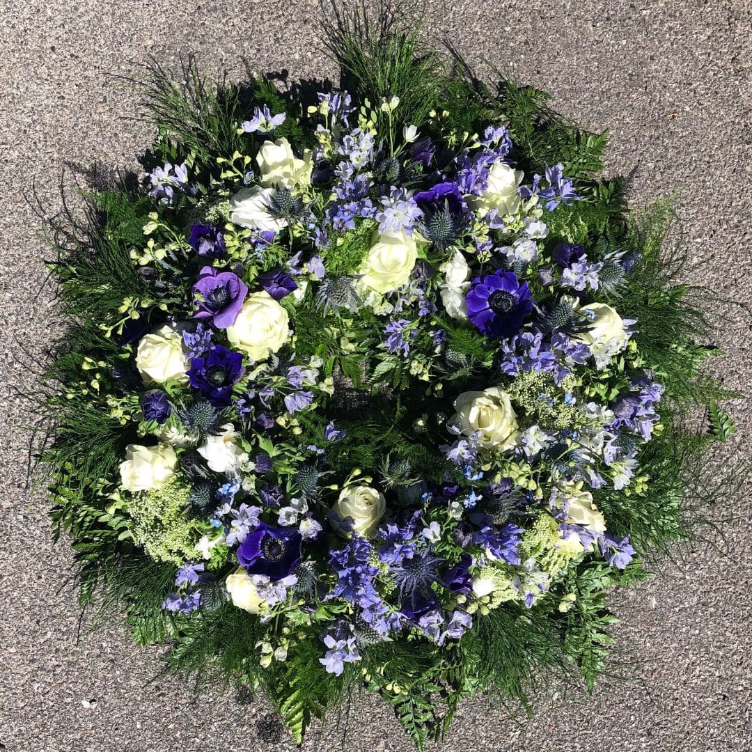 blomsterkrans til begravelse i blå og lilla farver