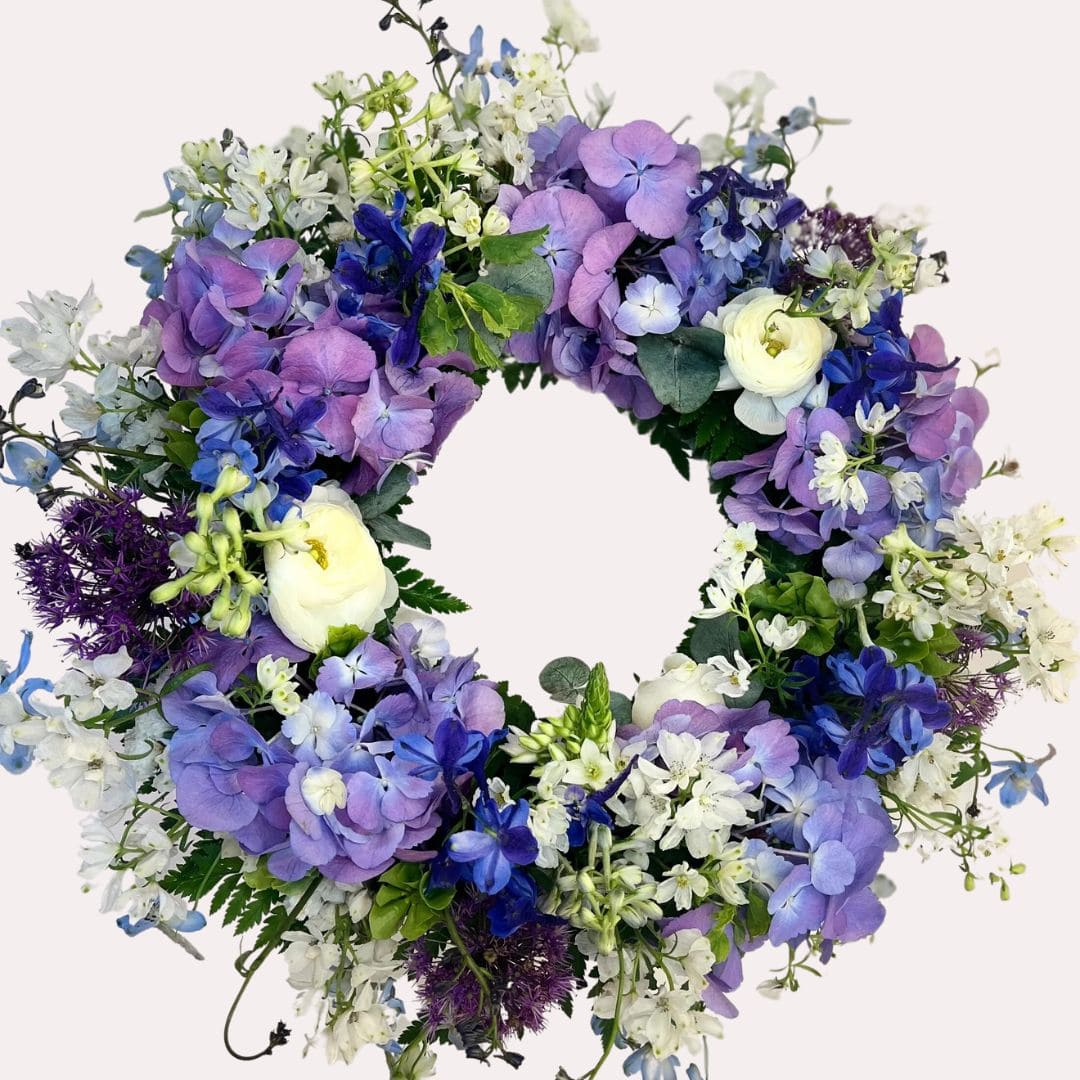 blomsterkrans til begravelse i blå og lilla farver