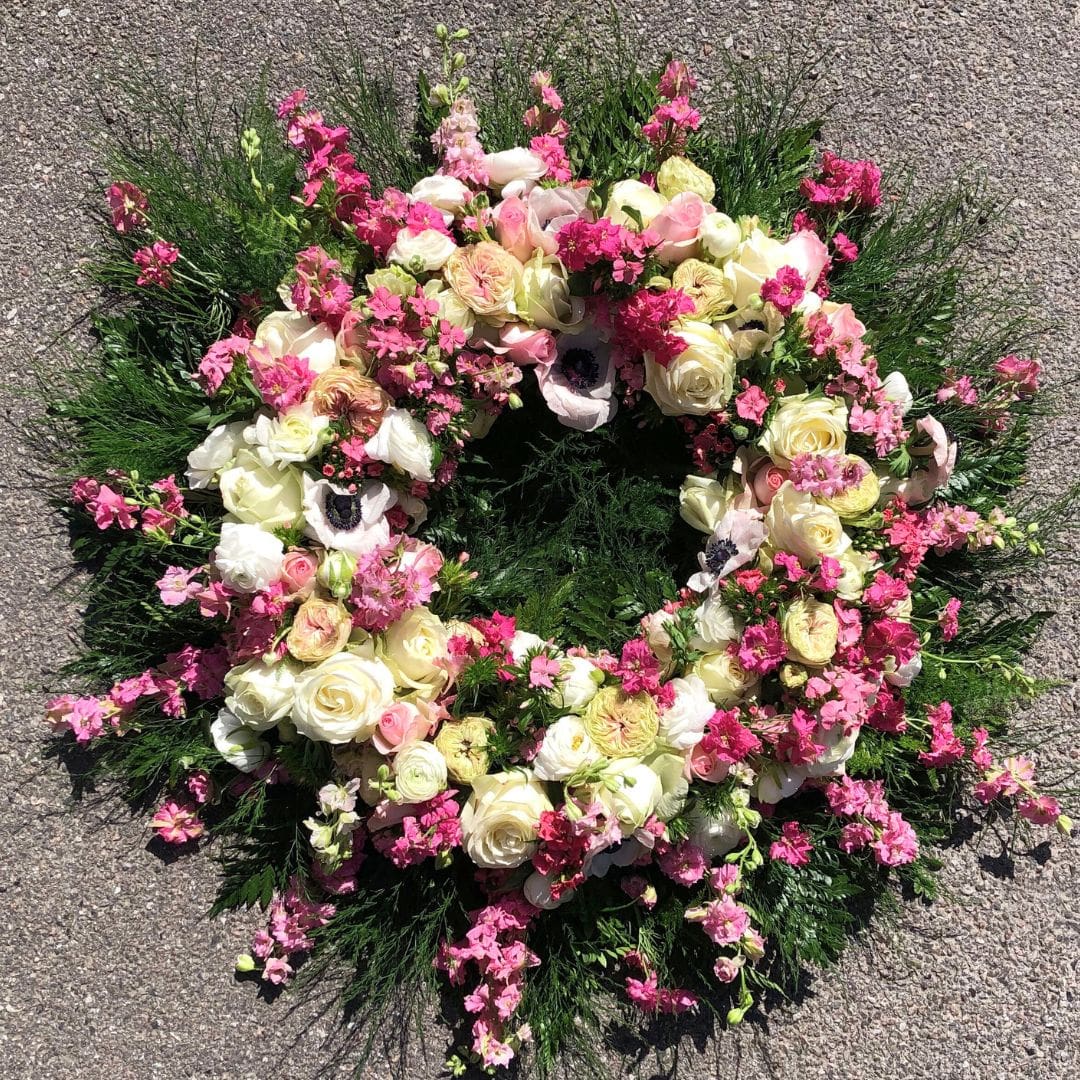 Blomsterkrans i smukke lyserøde farver og nuancer til begravelse og bisættelse