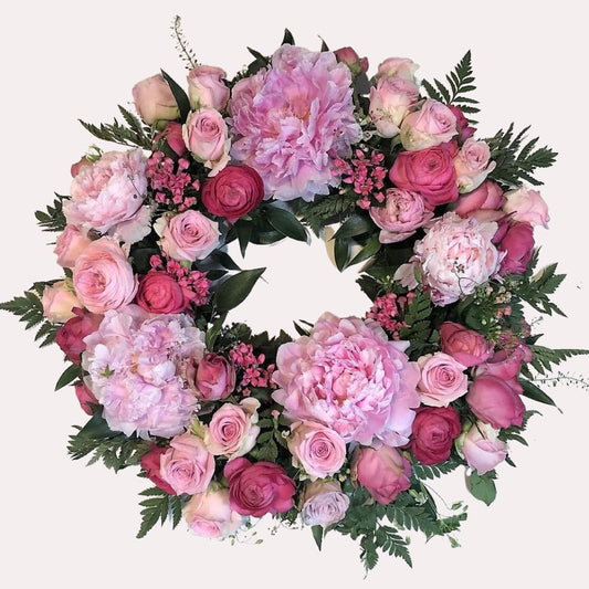 Blomsterkrans i smukke lyserøde farver og nuancer til begravelse og bisættelse
